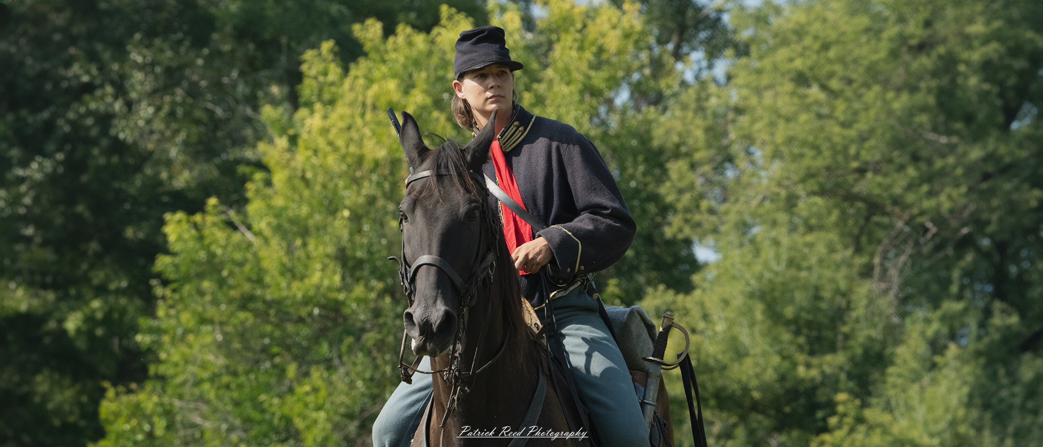 A female cavalry soldier on horseback, dressed in a military uniform that reflects the style of her era. She sits confidently in the saddle, holding the reins with one hand while the other rests on her weapon. Her determined expression embodies strength and bravery, showcasing the important role of women in cavalry units.